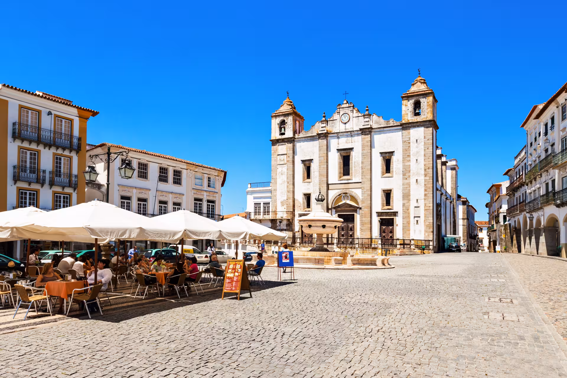 Charming Évora town square with outdoor cafes and historical architecture, showcasing cultural highlights of the Lisbon tour.