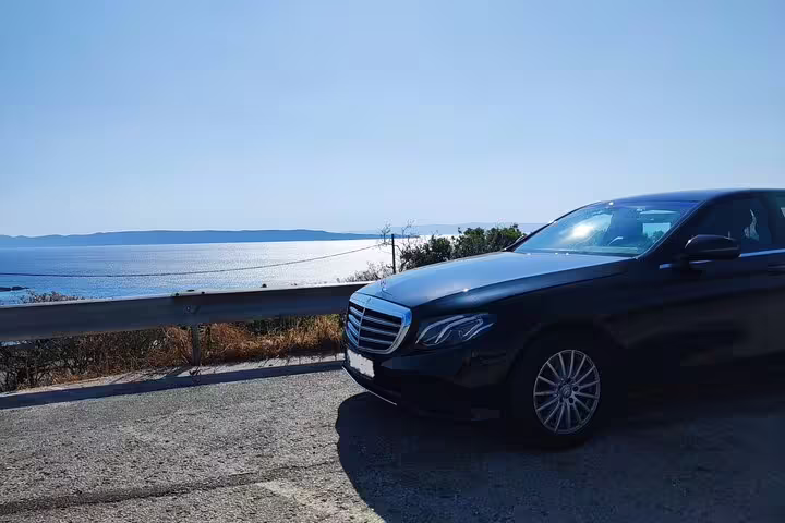 Executive Mercedes sedan by coastal road, private airport pickup and chauffeur transfer for stress-free arrivals