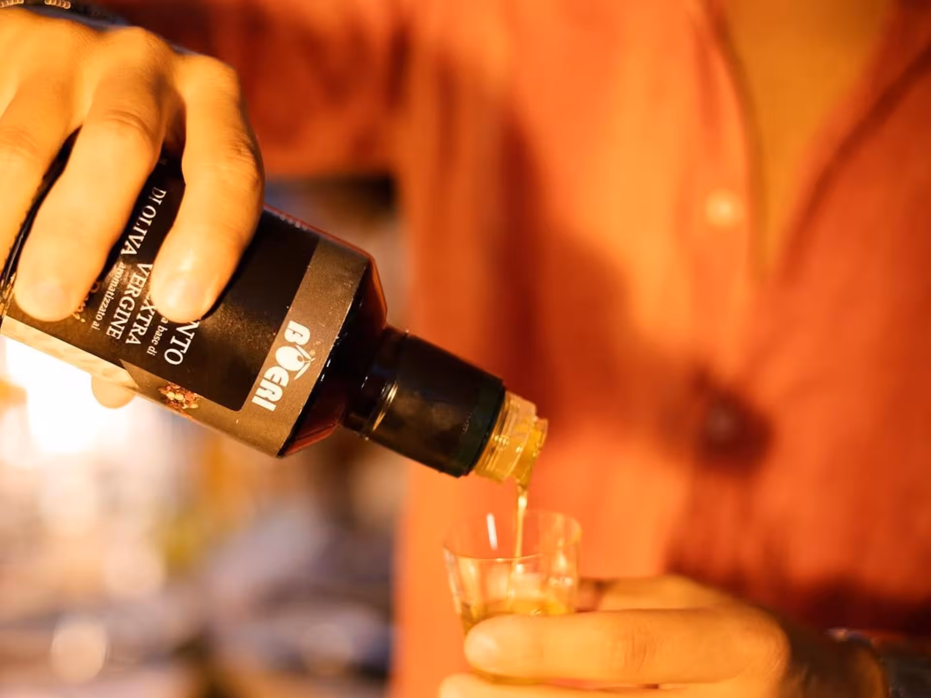 Pouring extra virgin olive oil into a glass during a tasting session in Taggia.