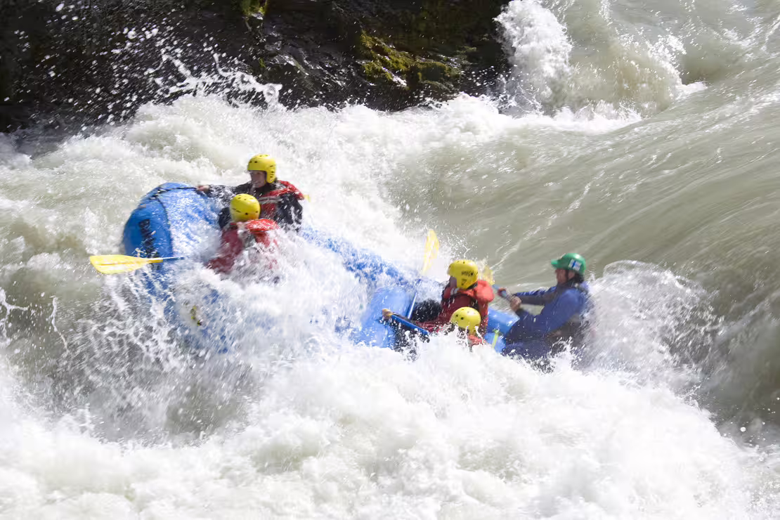 Adventurers navigate intense rapids on a thrilling extreme river rafting experience, showcasing teamwork and excitement.