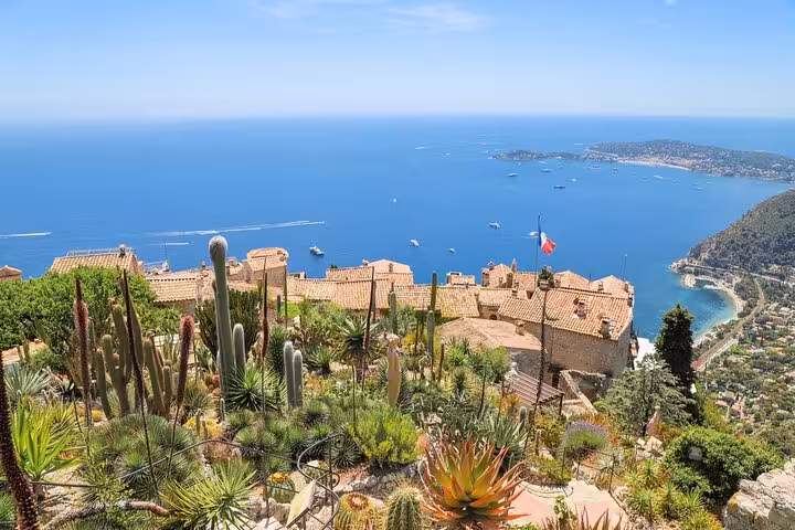 Stunning view of the Mediterranean Sea from Eze, showcasing lush gardens and ancient stone buildings.