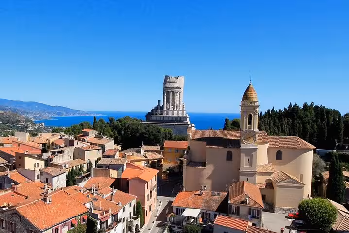 Panoramic view of Eze village with terracotta rooftops, church bell tower, and Mediterranean Sea on French Riviera