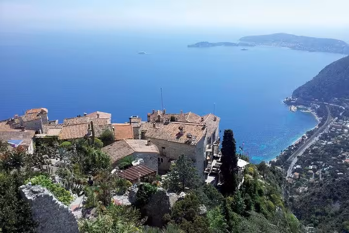 Aerial view of Eze village medieval stone buildings with terracotta roofs overlooking French Riviera coastline and Mediterranean Sea