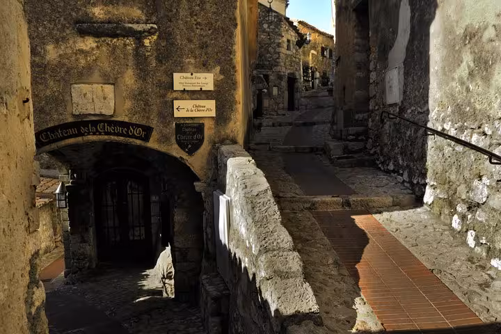Narrow medieval stone alley with Château de la Chèvre d'Or sign in Eze village, French Riviera