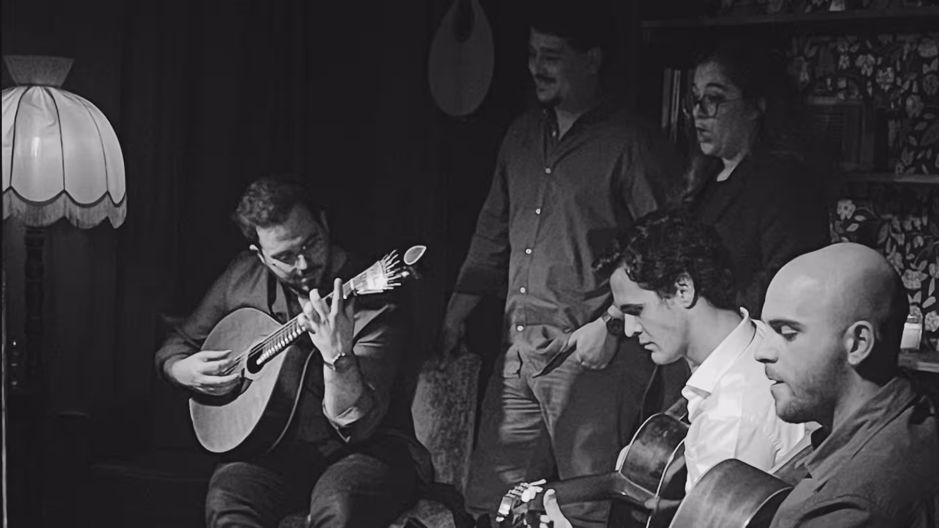 Black and white photo of a traditional Fado group performing passionately with classic Portuguese guitars.