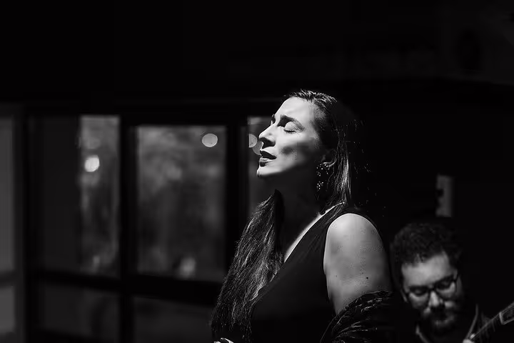 Fado singer passionately performing by Porto's riverfront, capturing the soulful essence of traditional Portuguese music.