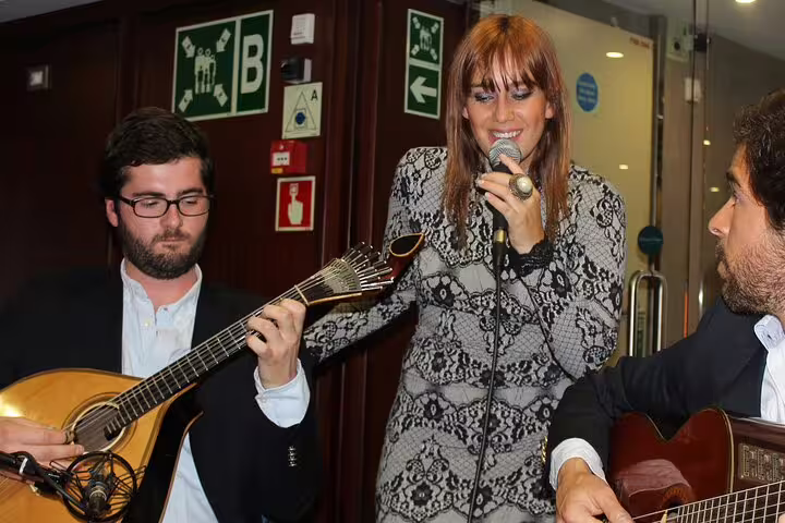 Musicians perform traditional Fado with guitars and singing in a cozy Lisbon neighborhood setting.