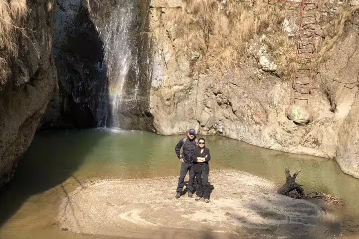 Couple standing by a waterfall pool in Fagaras mountains during a private hiking tour