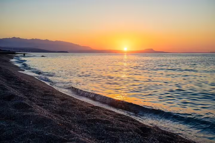 Breathtaking Falasarna Beach sunset with tranquil waves and golden sky, ideal for a serene private tour experience.