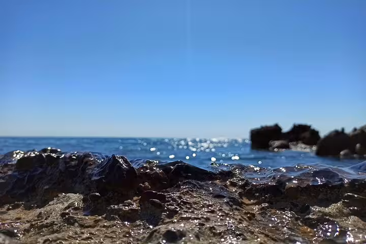 Close-up of sparkling blue waters and rocky shore at Falassarna Beach, perfect for a day trip from Chania.