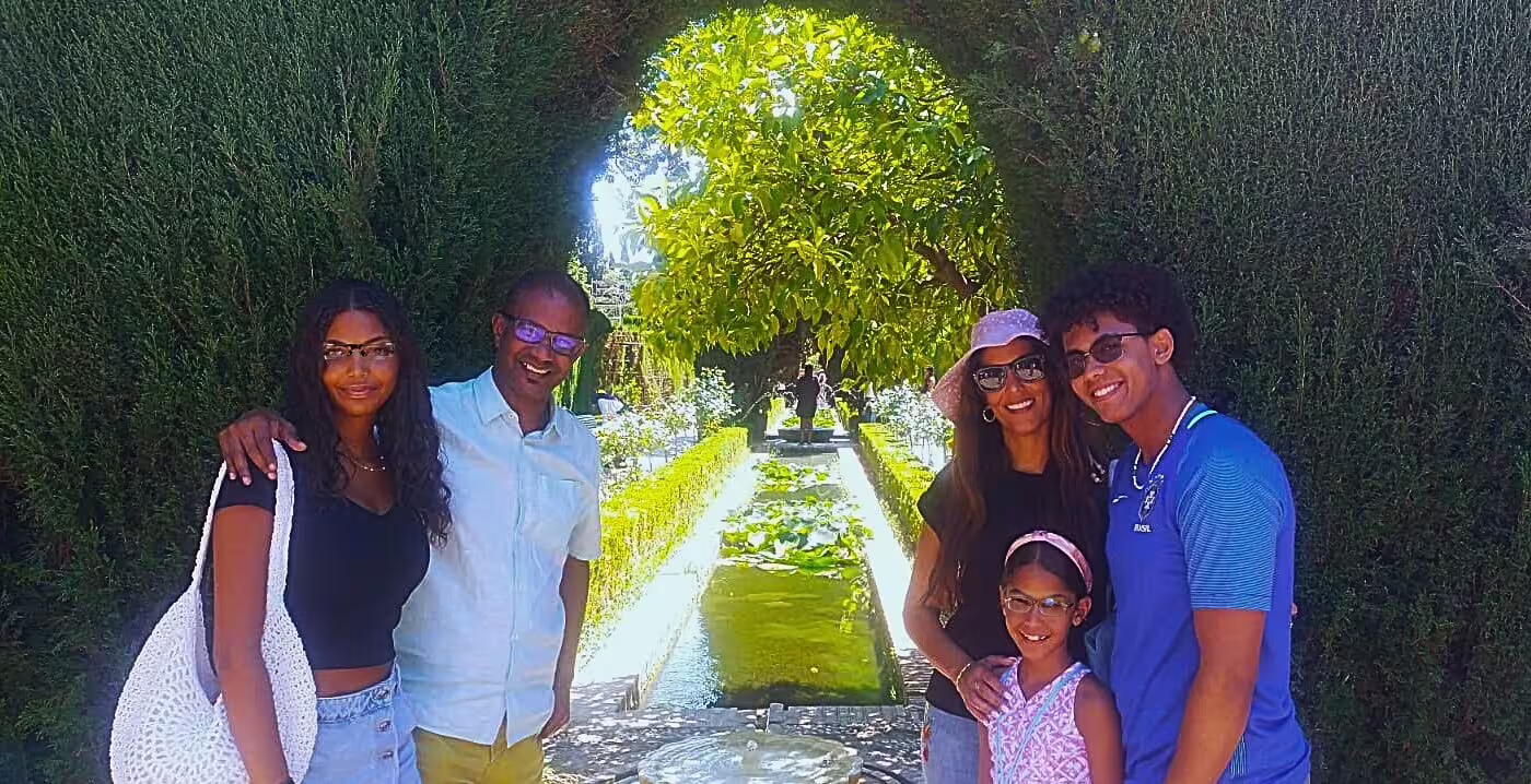Family photo in Alhambra Generalife gardens with fountains, on a Granada private tour with hotel pick-up