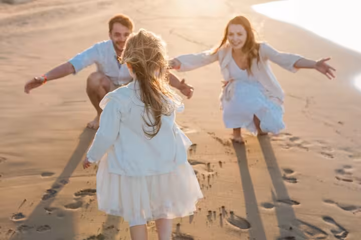 Family shares a heartwarming beach moment at sunset in Hersonissos, ideal setting for a private photoshoot.