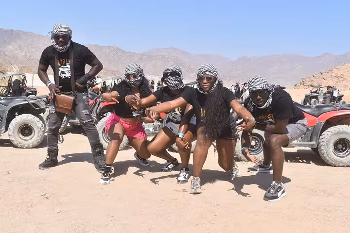 Group posing after Sharm El Sheikh family buggy safari, wearing scarves by parked desert buggies in Sinai