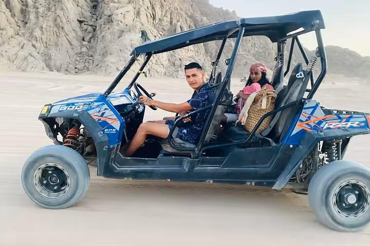 Couple riding 4-seat family buggy in Sharm El Sheikh, Sinai desert safari tour across sandy plains