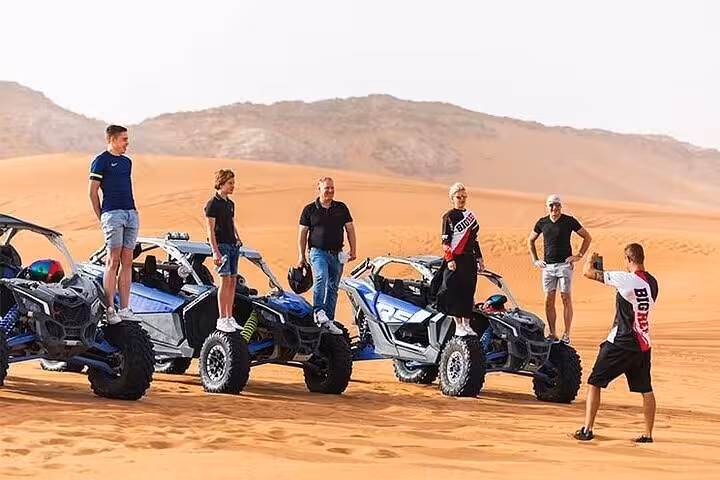 Group posing on family dune buggies in Sharm El Sheikh desert safari with sand dunes and mountains