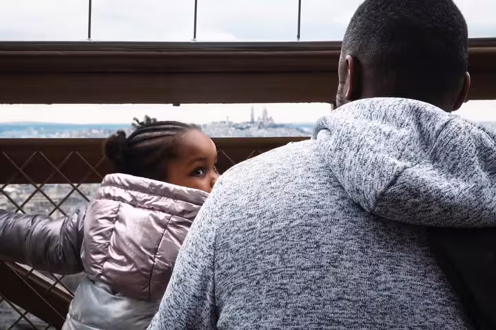 Father and child enjoying panoramic views of Paris from Eiffel Tower top floor observation deck