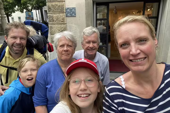 Family of six smiling together on a cobblestone street in Zurich during a walking tour