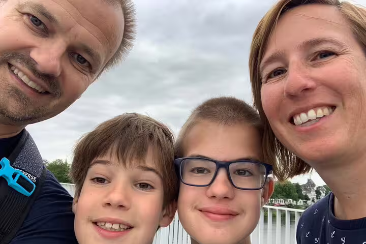 Family selfie by the Rhine in Bonn, enjoying an e-scavenger hunt city tour with smartphone clues and sights