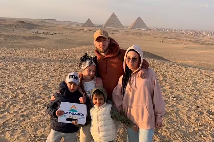 Family photo at Giza Pyramids desert viewpoint, highlight stop on 2-day Cairo and Giza tour from Alexandria