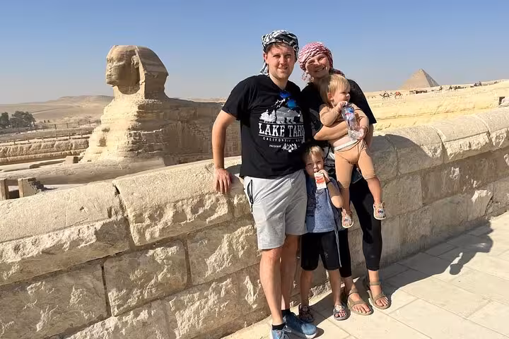 Family photo by the Great Sphinx and Giza Pyramids on VIP Giza tour with Grand Egyptian Museum visit
