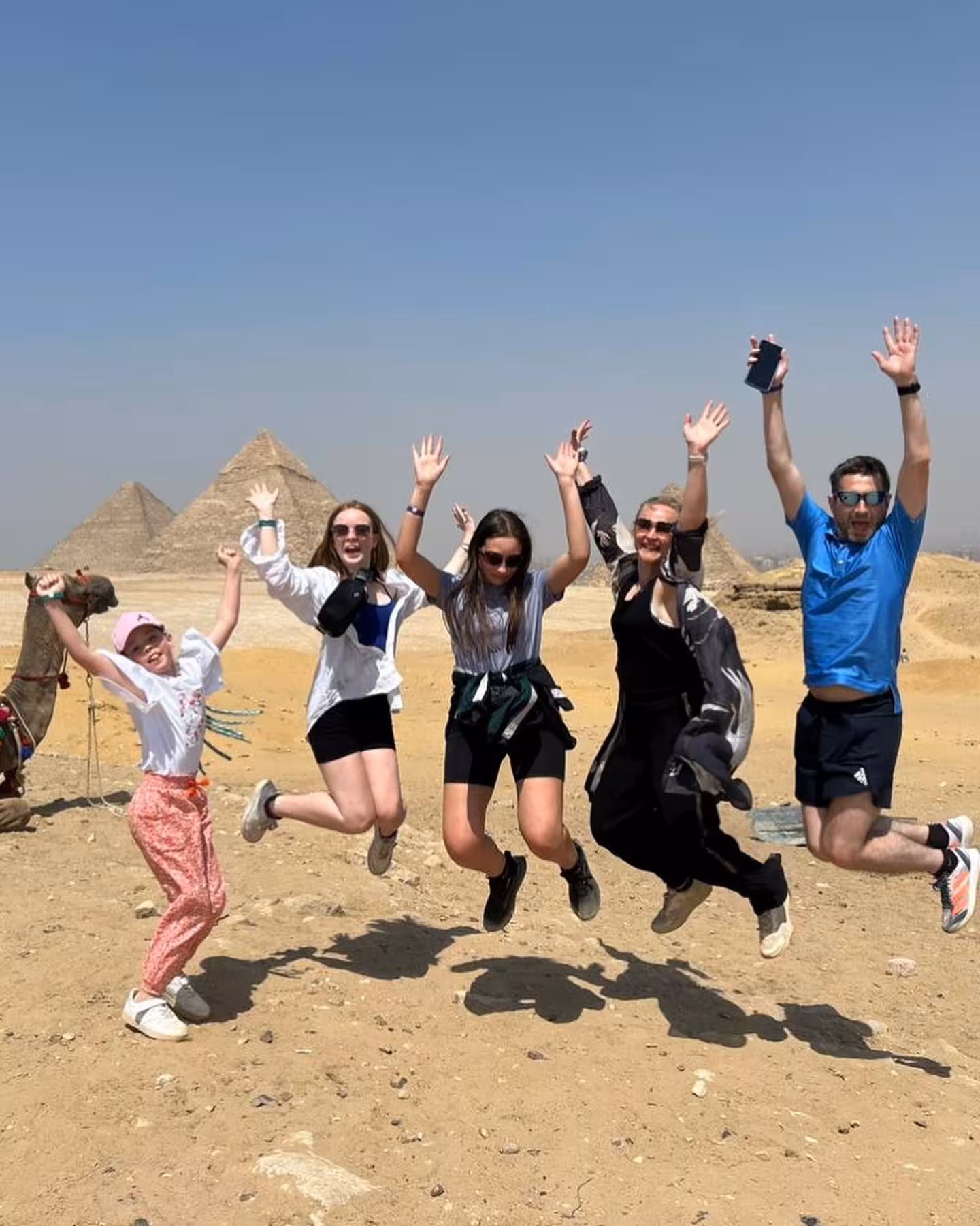 Family jumping by the Great Pyramids of Giza on a 4-day private Cairo Giza Alexandria and Fayoum tour