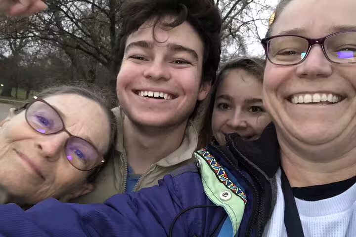Family of four smiling together outdoors during London self-guided walking tour in winter park
