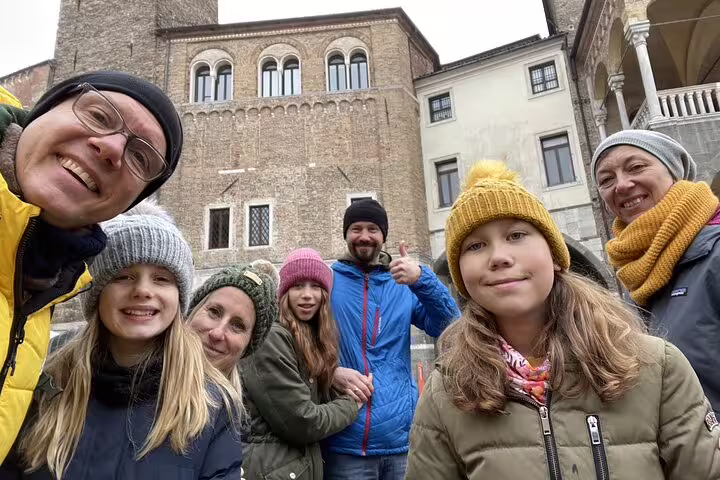 Group of families smiling together on a self-guided walking tour in Padua's historic square