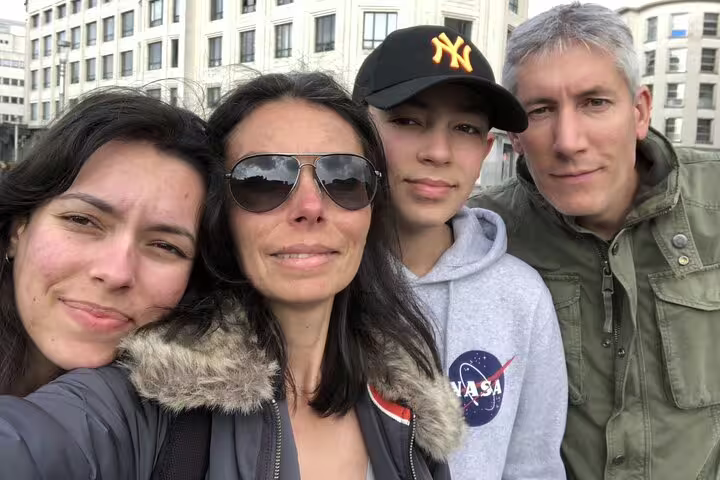 Family of four smiling together on a guided walking tour in Brussels city center