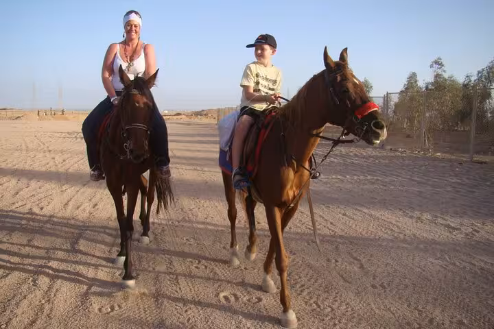 Family horseback riding in Hurghada desert, riders on sandy track during 2-hour beach & desert tour