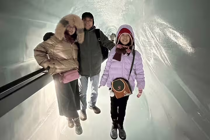 Family exploring the Ice Palace on a Jungfraujoch private day trip, surrounded by glistening ice walls.