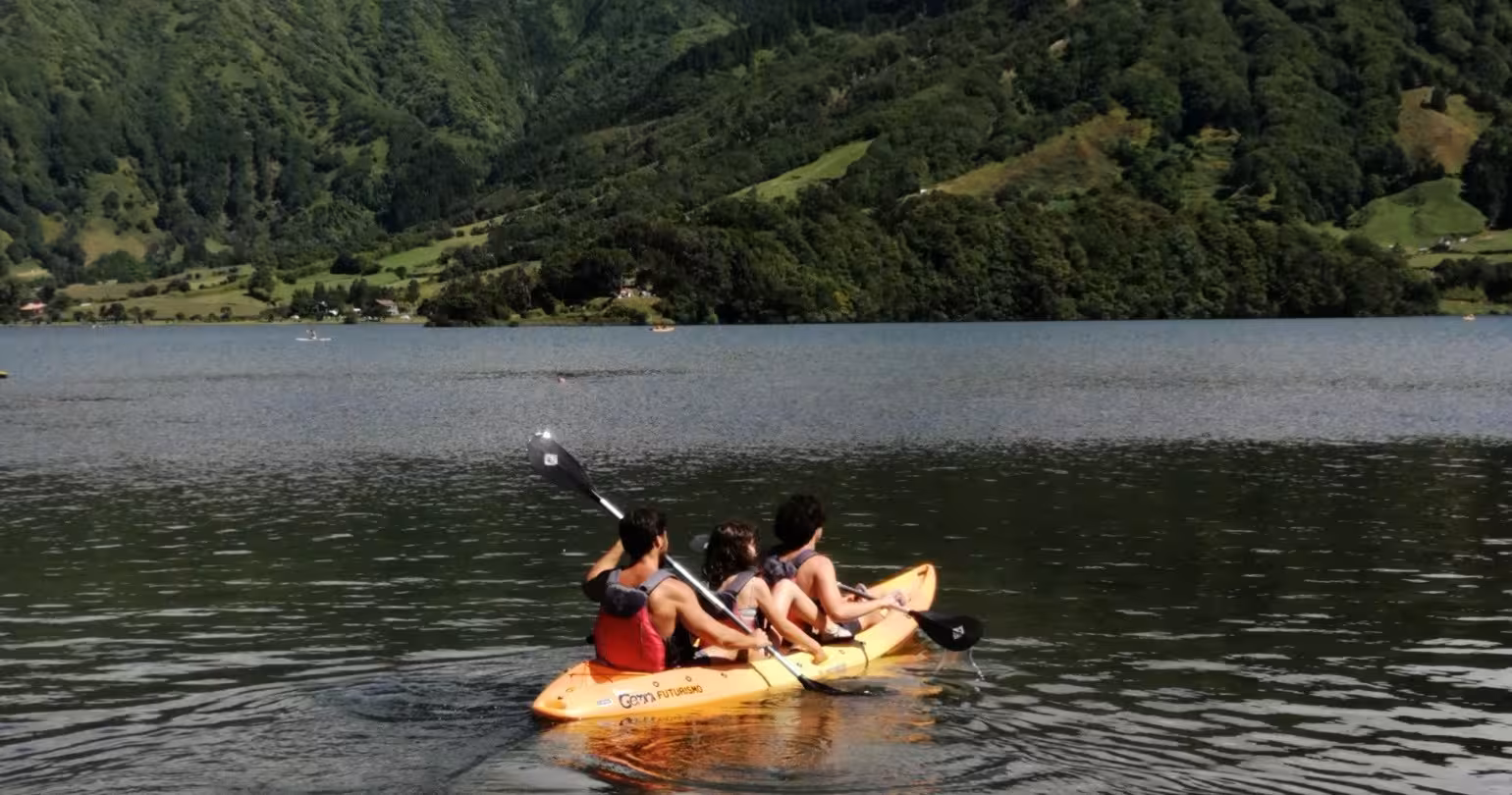 Family kayaking on Sete Cidades lake surrounded by lush volcanic hills on a half-day jeep and kayak tour in the Azores