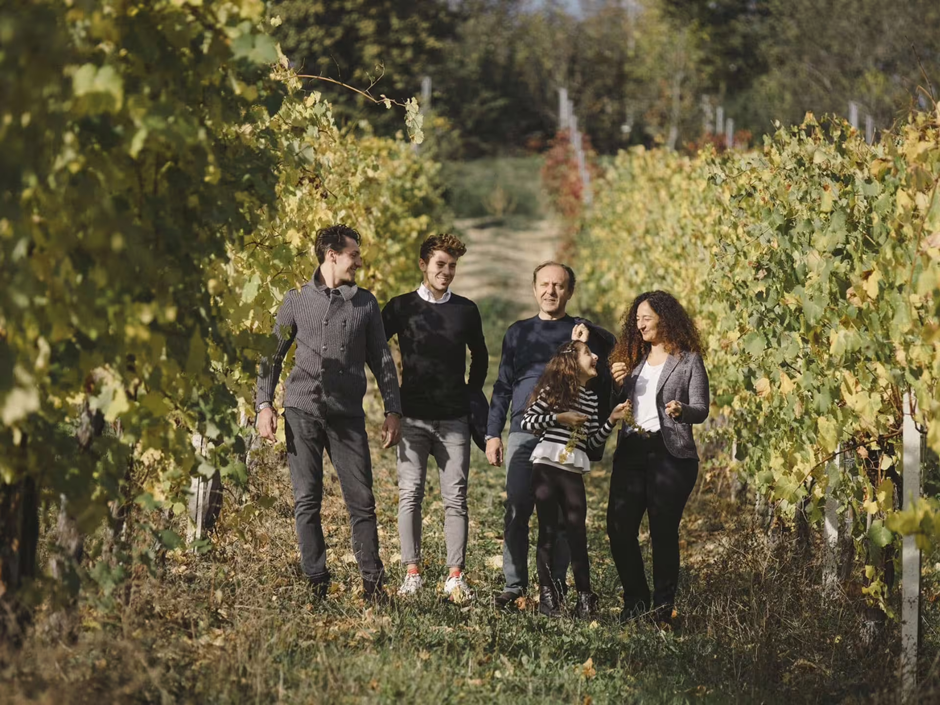 Family strolls through Modena vineyard during balsamic vinegar production tour and tasting experience