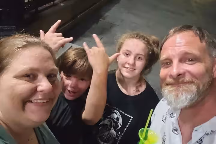 Family of four smiling at night during New Orleans French Quarter walking tour