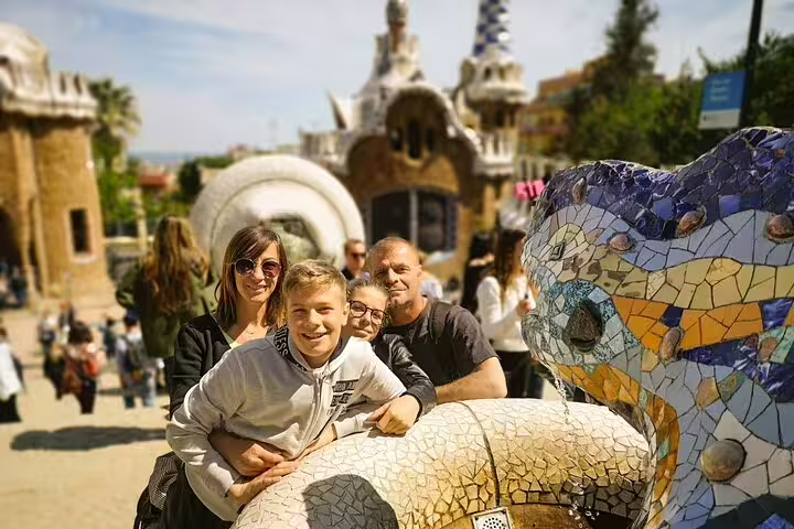 Family enjoying a sunny day at Park Güell, surrounded by Gaudí's colorful mosaics, part of the 2-day Gaudí and Montserrat tour.