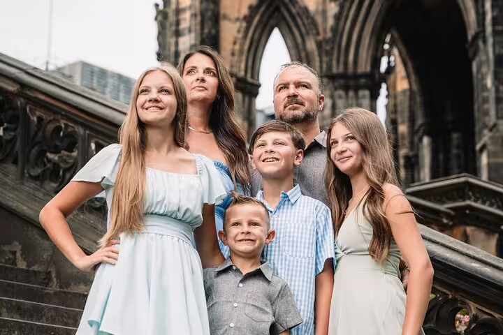 Family posing on historic steps near Edinburgh Castle, capturing a memorable moment during their private photoshoot.
