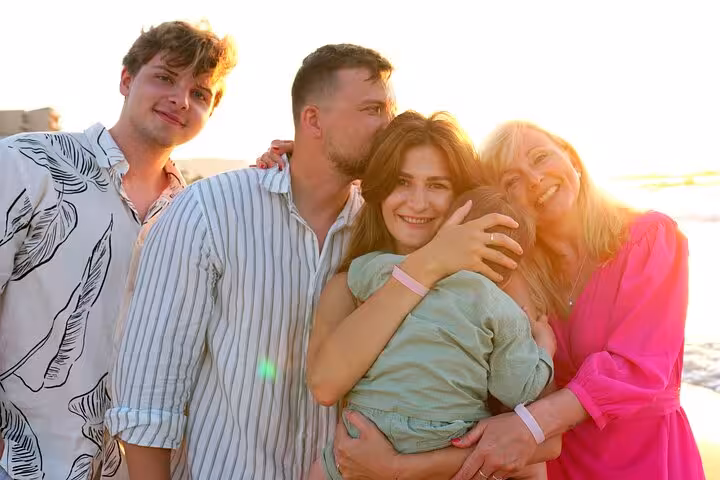 Happy family group embracing in the sunset during a private photoshoot at The Port of Hersonissos.
