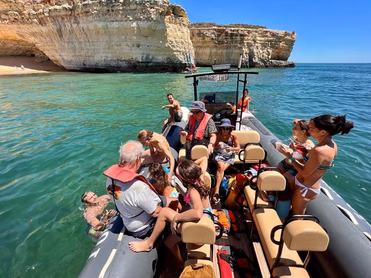 Family enjoying a private RIB boat tour near Benagil Caves, swimming and relaxing by Algarve’s golden cliffs and turquoise sea