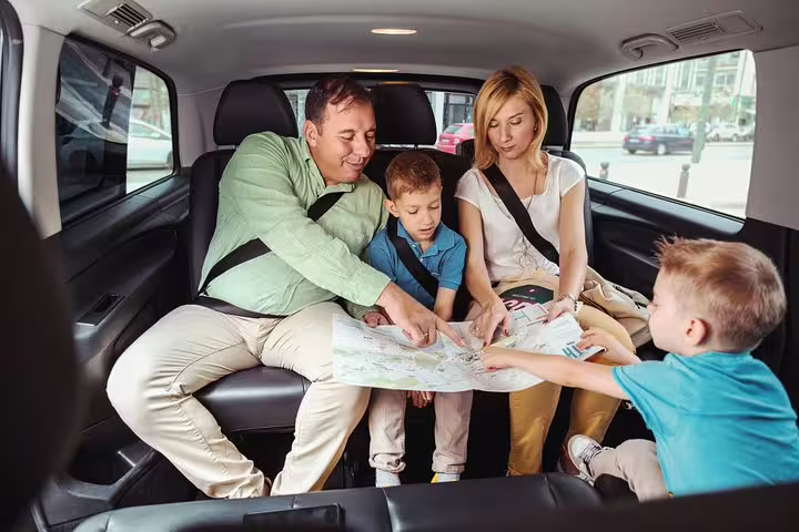 Family in private vehicle planning Santorini route with map during a 2-hour private sightseeing tour