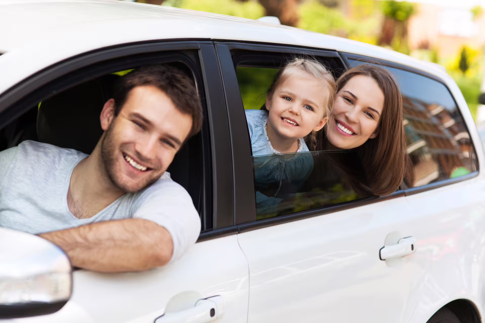 Happy family smiling from car windows during private transfer in Iceland