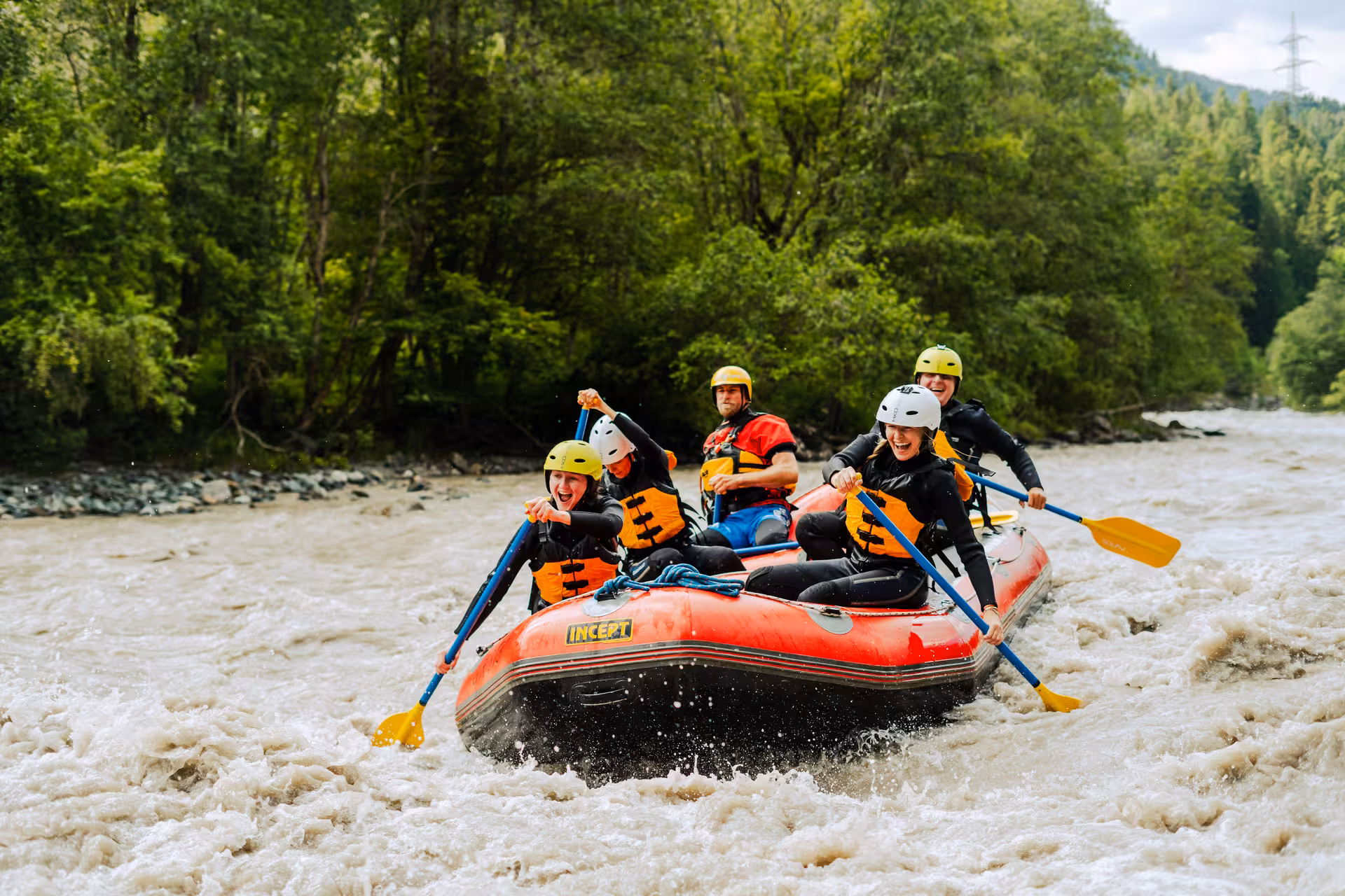 Family enjoying a thrilling rafting adventure on a wild river in Engadin, surrounded by lush green forests.