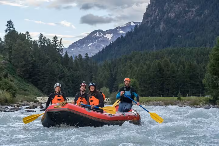 Family rafting adventure in Engadin with stunning mountain views and clear, rushing river waters.