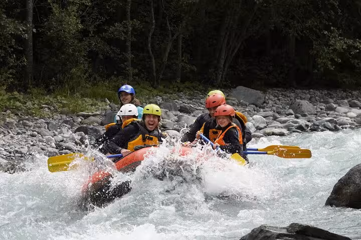 Group navigating Engadin's whitewater rapids during an exhilarating family rafting experience.