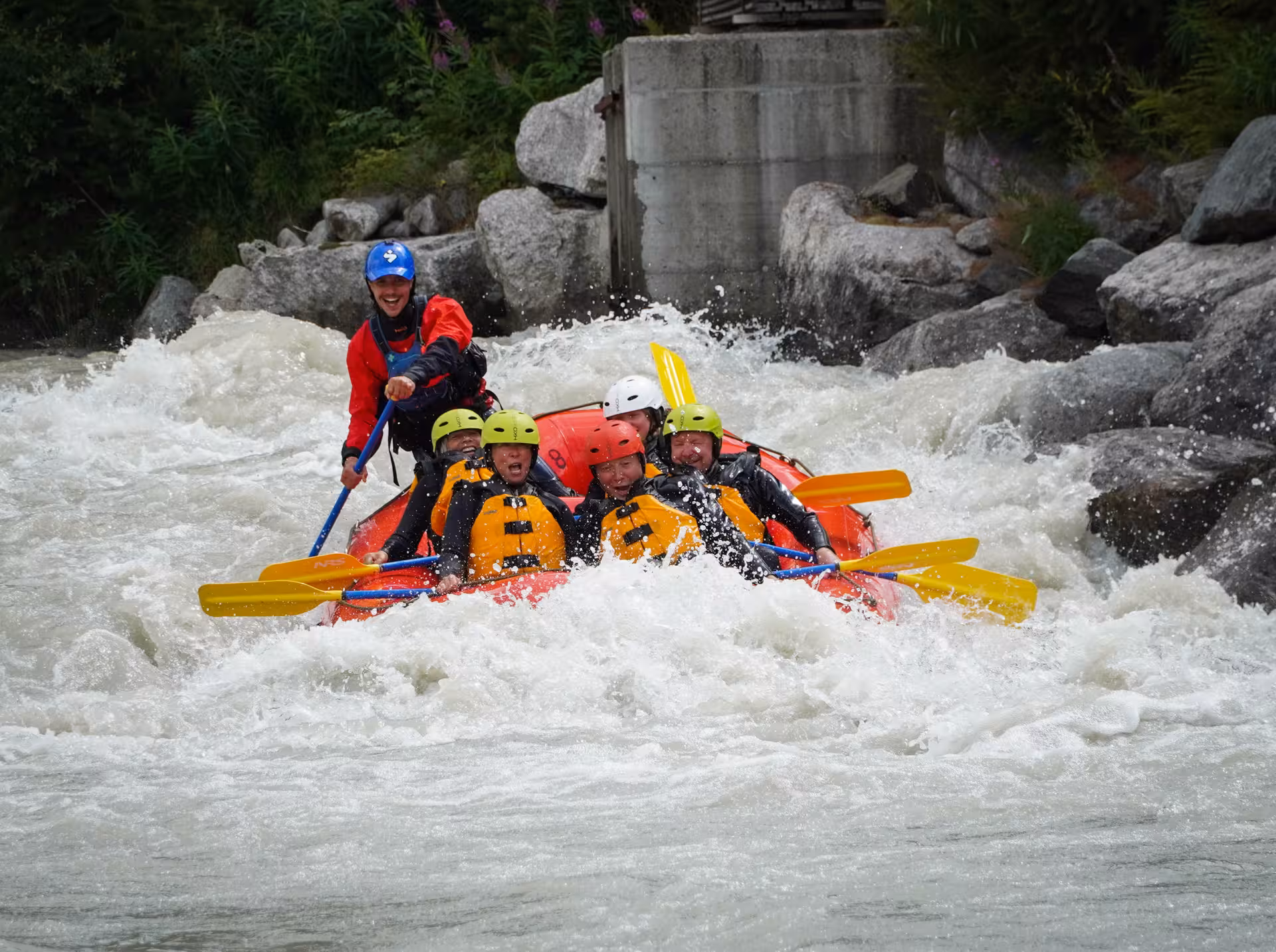 Group braving whitewater rapids during the Engadin family rafting tour, highlighting adventure and fun.
