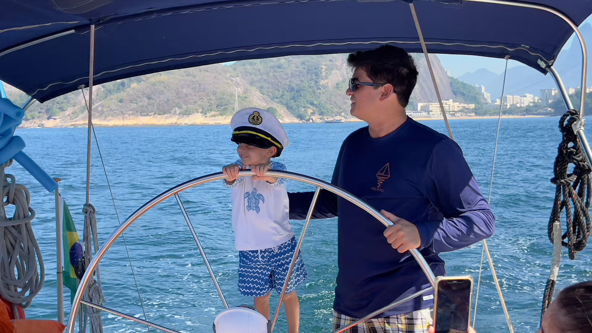 Family steering a sailboat on a whale watching expedition, cruising coastal waters on a guided marine tour