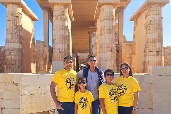 Family poses in front of ancient columns at Saqqara, showcasing the rich history and architecture of the site.