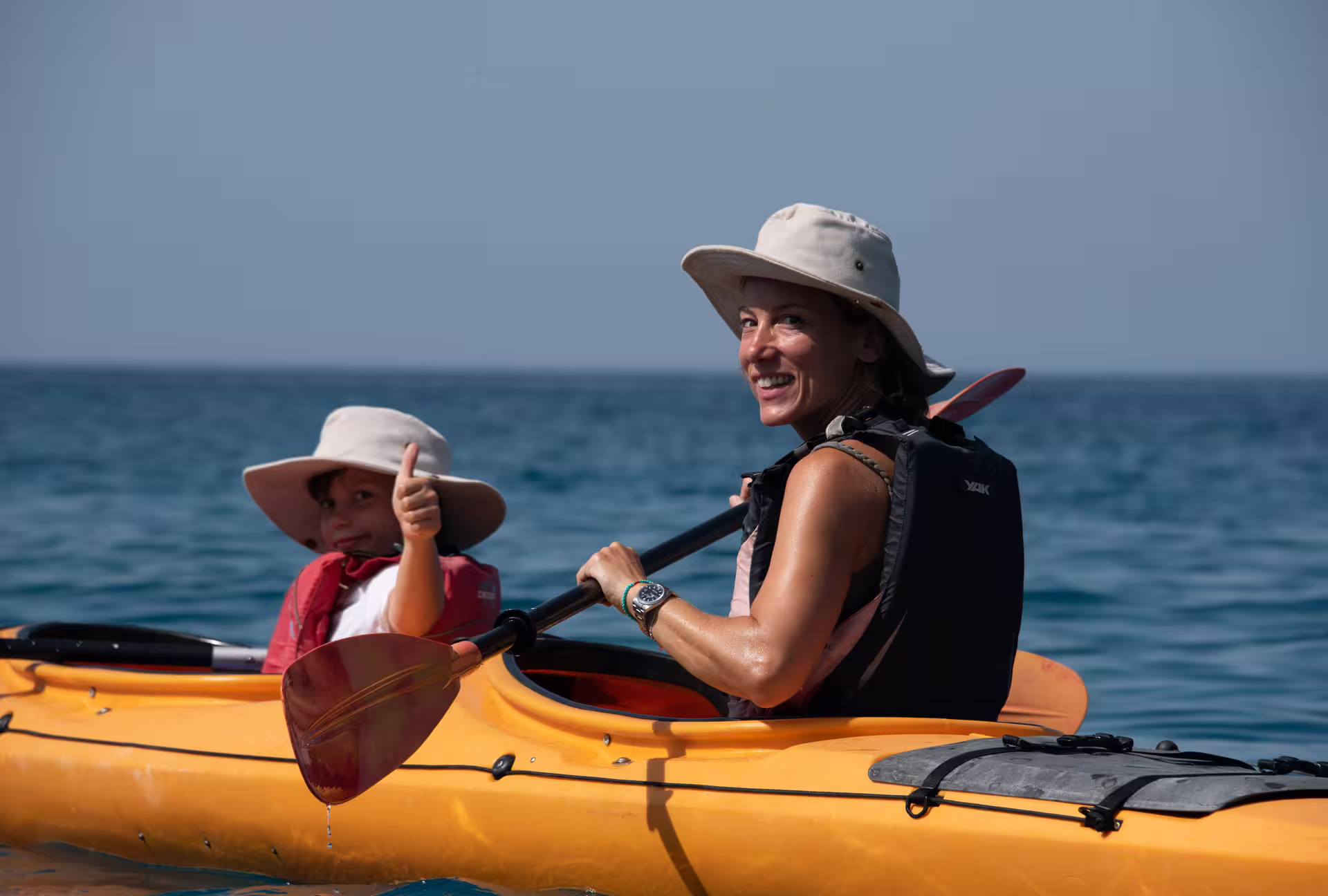 Family sea kayaking in Kardamyli and Stoupa, Messinia, with life jackets and paddles on calm Aegean water