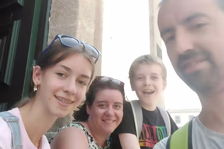 Family of four smiling together during self-guided walking tour in Braga, Portugal