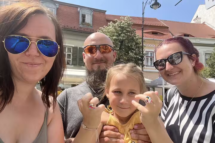 Family smiling on a sunny street in Sibiu Old Town during a self-guided walking tour