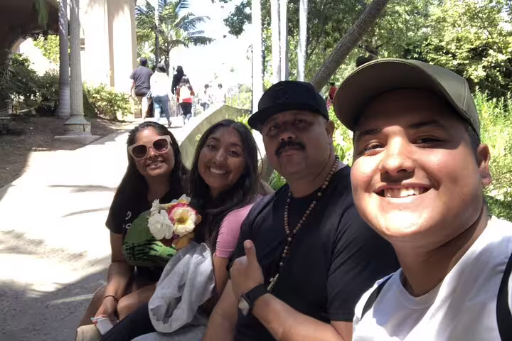 Family of four smiling for selfie at Balboa Park San Diego on walking tour