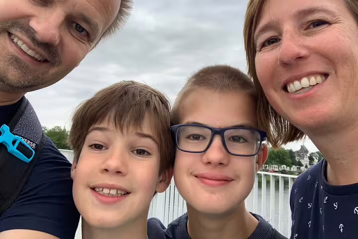 Family selfie on a Hamburg bridge during an e-scavenger hunt, exploring the city at their own pace